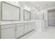 Bright bathroom featuring double vanity, quartz countertop, and a glass-enclosed shower and a walk-in closet at 31430 Hayman Loop, Wesley Chapel, FL 33545