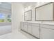 Modern bathroom featuring double vanity with white cabinets, quartz countertops, and tiled floors at 31430 Hayman Loop, Wesley Chapel, FL 33545