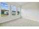 Bright bedroom featuring plush carpeting, three large windows, and neutral paint at 31430 Hayman Loop, Wesley Chapel, FL 33545