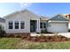 Charming single-story home featuring a manicured lawn, craftsman details, and a welcoming two-car garage at 31430 Hayman Loop, Wesley Chapel, FL 33545