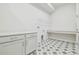 Bright laundry room with patterned tile flooring, shaker cabinets, and countertop space at 31430 Hayman Loop, Wesley Chapel, FL 33545