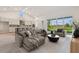 Open living room with modern decor, lots of seating and pond view through the windows at 31430 Hayman Loop, Wesley Chapel, FL 33545