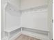 Well-lit mudroom with white bench, hooks, and shelves provides storage and organization at 31430 Hayman Loop, Wesley Chapel, FL 33545