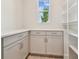 Neutral toned pantry features counter space, storage cabinets and open shelving at 31430 Hayman Loop, Wesley Chapel, FL 33545