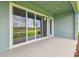 Covered patio features pond view, large sliding doors and neutral color palette at 31430 Hayman Loop, Wesley Chapel, FL 33545