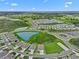 An aerial view of a well-planned community featuring lush green spaces and serene lakes under a blue sky at 3528 Golden Wheat Ln, Plant City, FL 33565