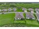 Aerial view of homes nestled within a community with lush greenery and large backyards at 3528 Golden Wheat Ln, Plant City, FL 33565