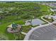 Aerial view showcasing the community's playground, basketball court, parking area, and the lush surrounding landscape at 3528 Golden Wheat Ln, Plant City, FL 33565
