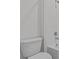 Bright bathroom featuring a toilet, shower, and white tiled wall at 3528 Golden Wheat Ln, Plant City, FL 33565