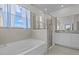Bright bathroom features a soaking tub, glass shower, granite counter, and a window with curtains at 3528 Golden Wheat Ln, Plant City, FL 33565