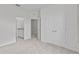 Bedroom with doors leading to bathroom and closet featuring neutral carpet and light grey walls at 3528 Golden Wheat Ln, Plant City, FL 33565