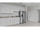 White kitchenette with granite countertops, stainless steel fridge, and tiled floors at 3528 Golden Wheat Ln, Plant City, FL 33565