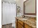 Bathroom boasts a granite-topped vanity and decorative framed mirror with walk-in shower at 3668 Janus Way, Palm Harbor, FL 34685