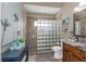 Stylish bathroom featuring a glass block shower, granite countertop, and dark wood vanity for a modern yet comforting design at 3668 Janus Way, Palm Harbor, FL 34685