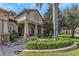 Inviting front yard with lush landscaping and stone accents leading to the entryway at 3668 Janus Way, Palm Harbor, FL 34685