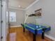 Bright game room featuring hardwood floors, a window, and a blue air hockey table at 3668 Janus Way, Palm Harbor, FL 34685