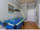 Bright game room featuring hardwood floors and a blue air hockey table for entertainment at 3668 Janus Way, Palm Harbor, FL 34685