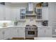 Kitchen view showcasing the stainless steel range and hood, marble counters and white cabinetry at 3668 Janus Way, Palm Harbor, FL 34685