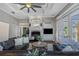 Living room features coffered ceiling, fireplace with a black brick hearth and access to patio at 3668 Janus Way, Palm Harbor, FL 34685