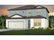 Charming two-story home showcasing a light blue and white color scheme, paired with a two-car garage and inviting front lawn at 37195 Clinch Cir, Zephyrhills, FL 33540