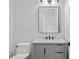 Modern bathroom with a gray vanity, marble countertop, sleek black hardware, and a frameless mirror offering a clean aesthetic at 3815 W Obispo St, Tampa, FL 33629