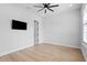 Bedroom features wood floors, ceiling fan, a wall-mounted TV and natural light at 3815 W Obispo St, Tampa, FL 33629