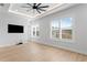 Well-lit bedroom with wood floors, plantation shutters, and a wall-mounted TV at 3815 W Obispo St, Tampa, FL 33629