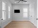 Neutral bedroom featuring wood floors, plantation shutters, a ceiling fan and a wall mounted tv at 3815 W Obispo St, Tampa, FL 33629