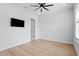 Bright bedroom featuring a modern ceiling fan, wood flooring, and a door that provides entry at 3815 W Obispo St, Tampa, FL 33629