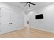 Large primary bedroom with wood flooring, walk-in closets, and a modern ceiling fan at 3815 W Obispo St, Tampa, FL 33629