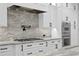Modern kitchen featuring white cabinets, granite countertops, stainless steel appliances, and stylish backsplash at 3815 W Obispo St, Tampa, FL 33629