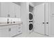 Well-organized laundry room with sleek cabinets, stone counters, and convenient stacked washer/dryer at 3815 W Obispo St, Tampa, FL 33629