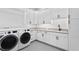 Bright laundry room with white cabinets, gray countertop, dark hardware, modern washer and dryer at 3815 W Obispo St, Tampa, FL 33629