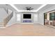 Bright living room featuring a fireplace, ceiling fan, wood floors, and sliding doors to the outside at 3815 W Obispo St, Tampa, FL 33629