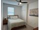 Comfortable bedroom with a ceiling fan, decorative painting, and a bed with light green accents at 43314 Water Bird Way # 6712, Punta Gorda, FL 33982