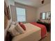 Cozy bedroom featuring a mirror over the dresser, a decorative lamp, and bed with coral accents at 43314 Water Bird Way # 6712, Punta Gorda, FL 33982