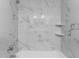Modern bathroom featuring white marble tile and shower with built-in shelving at 4714 Kemble Ct, Tampa, FL 33624