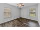 Cozy bedroom with wood-look tile flooring, ceiling fan, and two windows with blinds at 4714 Kemble Ct, Tampa, FL 33624