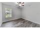 Bedroom boasts wood-look tile flooring, a window with blinds, and a ceiling fan at 4714 Kemble Ct, Tampa, FL 33624