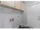 Laundry room featuring overhead cabinets, connections, and door to the exterior at 4714 Kemble Ct, Tampa, FL 33624