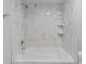 The remodeled bath and shower combo with marble tiling, fixtures, and built-in shelving at 4714 Kemble Ct, Tampa, FL 33624