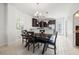 An elegant dining area with an inviting dark wood table, modern lighting, and seamlessly connected kitchen for easy entertaining at 4859 W Prescott St, Tampa, FL 33616