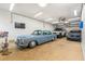 Spacious garage featuring multiple vehicles, ample lighting, and a ceiling fan for climate control at 4859 W Prescott St, Tampa, FL 33616