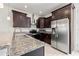 A stylish kitchen featuring dark cabinets, granite countertops, and stainless steel appliances, ideal for cooking and entertaining at 4859 W Prescott St, Tampa, FL 33616