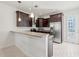 A stylish kitchen featuring dark cabinets, granite countertops, stainless steel appliances, and a breakfast bar for casual dining at 4859 W Prescott St, Tampa, FL 33616