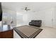 Bright living room featuring modern tile flooring, ceiling fan, and a comfortable reclining sofa at 4859 W Prescott St, Tampa, FL 33616