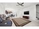 Open-concept living area with tile floors, ceiling fan, and dark sofa, leading to dining and kitchen areas at 4859 W Prescott St, Tampa, FL 33616