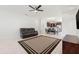 Open-concept living area with tile floors, ceiling fan, and dark sofa, leading to dining and kitchen areas at 4859 W Prescott St, Tampa, FL 33616