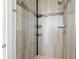 Sleek shower featuring gray stone-look tiling, glass doors, and storage caddies at 4859 W Prescott St, Tampa, FL 33616