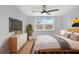 This modern bedroom features neutral tones, a large window and beautiful hardwood floors at 5200 Dove Dr, New Port Richey, FL 34652